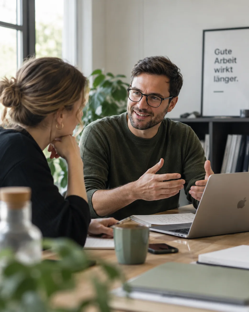 Mitarbeiterin und Mitarbeiter im Gespräch am Besprechungstisch